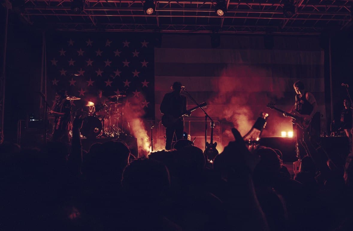 The stage washed in red light after dark, the band in silhouette against the hung flag.