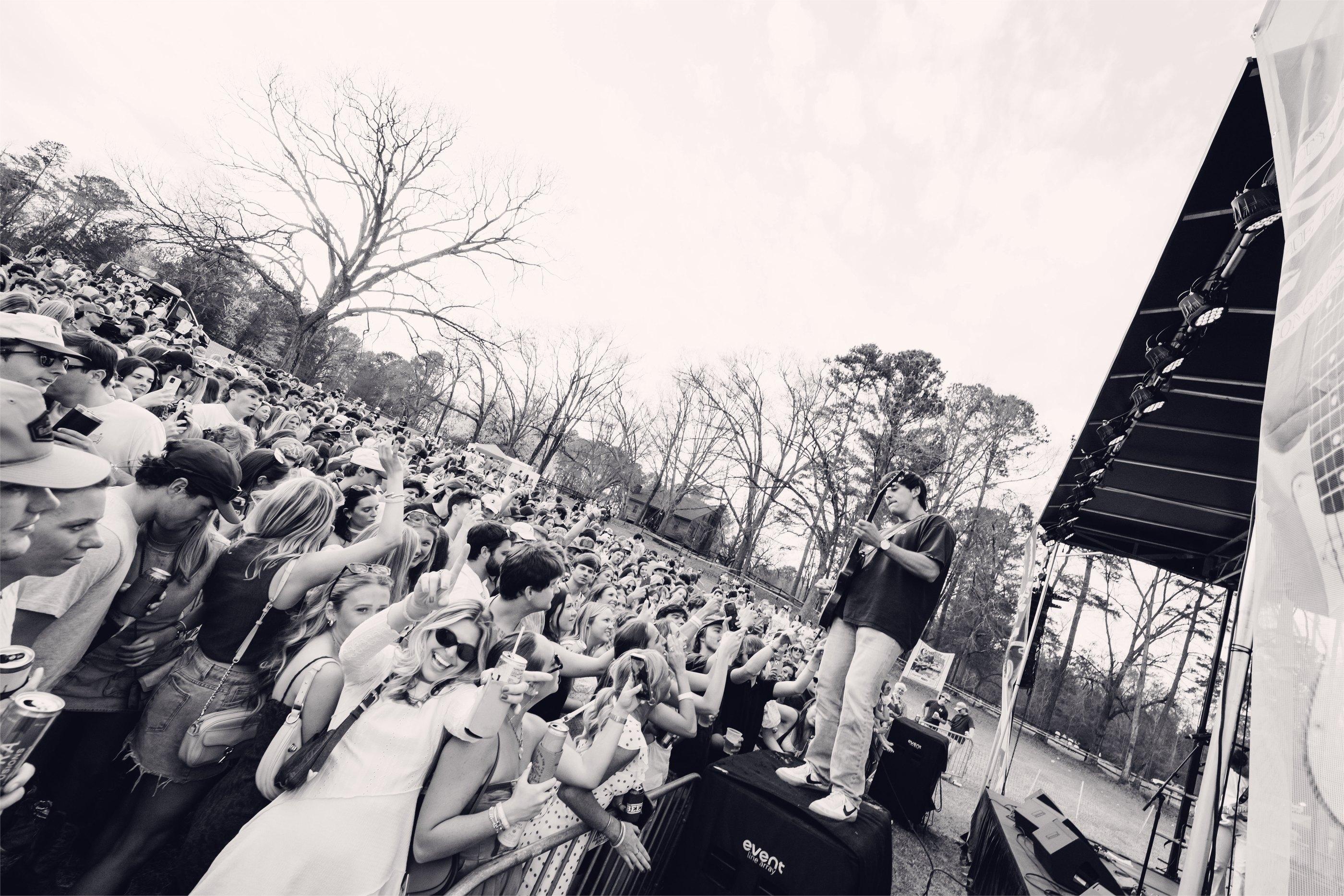 A black-and-white view along the barricade, the crowd running back through bare Georgia pines.